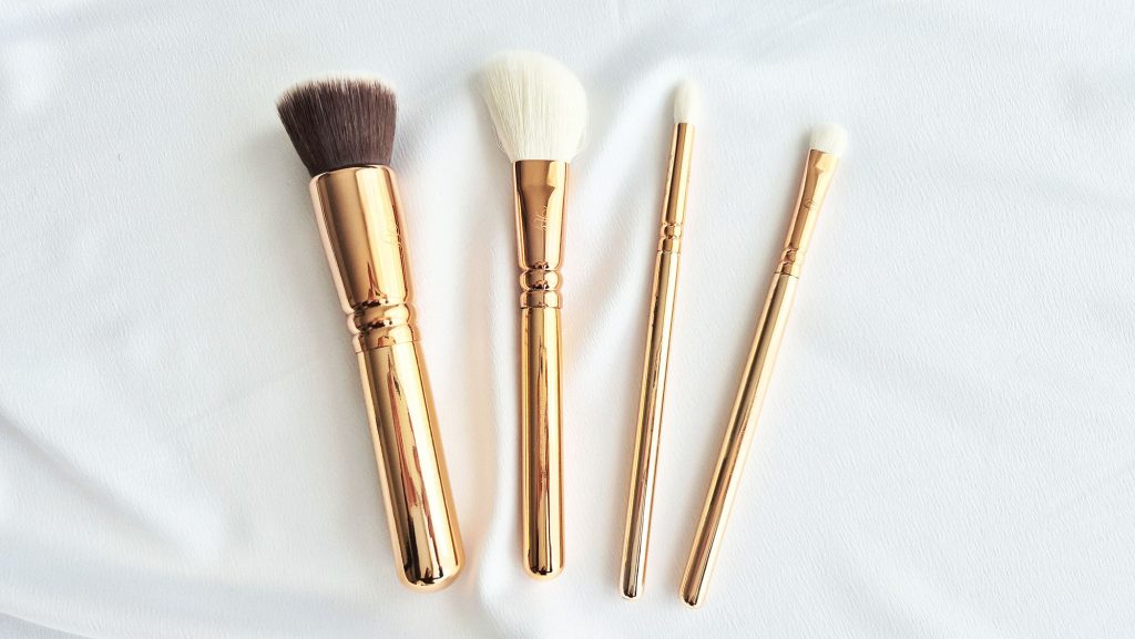 Focus sur quatre pinceaux maquillage Zoeva : un pinceau poudre large, un pinceau blush biseauté et deux pinceaux yeux.