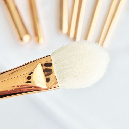 Pinceau en forme de flamme effilée pour poudrer l'anti-cernes.