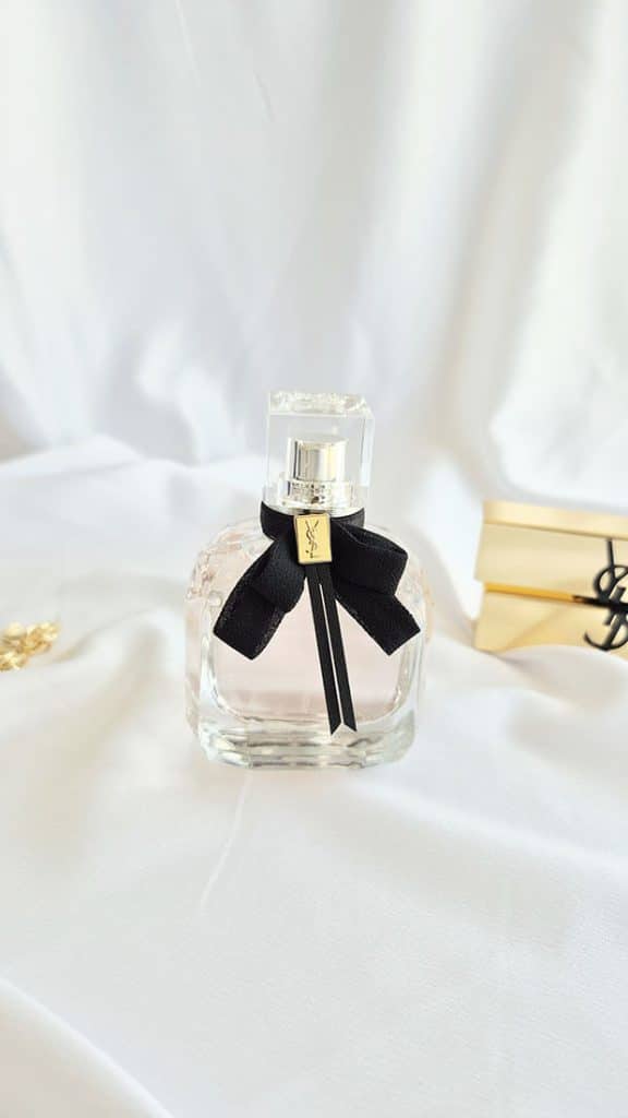 Gros plan sur le flacon Mon Paris Yves Saint Laurent avec nœud noir et logo doré