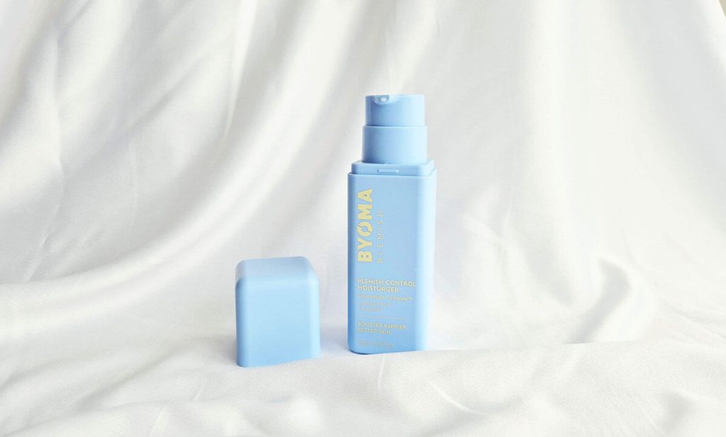 Packaging bleu pastel du Blemish Control Byoma avec flacon pompe minimaliste posé sur un tissu blanc.