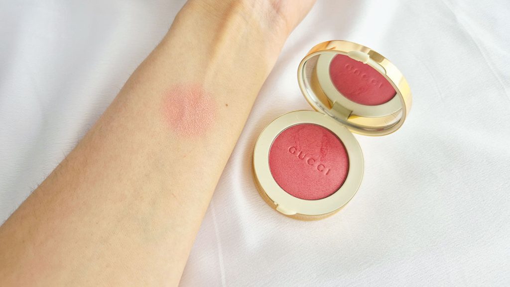 Swatch du Gucci Glow Blush Fresh Coral sur peau claire à côté du blush ouvert