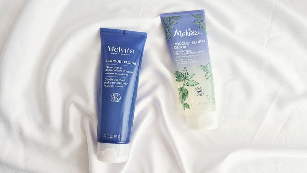 Ancien et nouveau packaging du Gel-En-Huile Démaquillant Melvita sur drap blanc