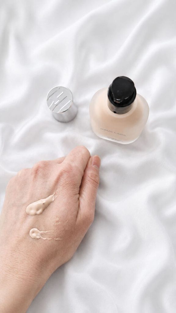 Deux gouttes de fond de teint Haus Labs fluide sur le dos d'une main pour tester la texture sérum.