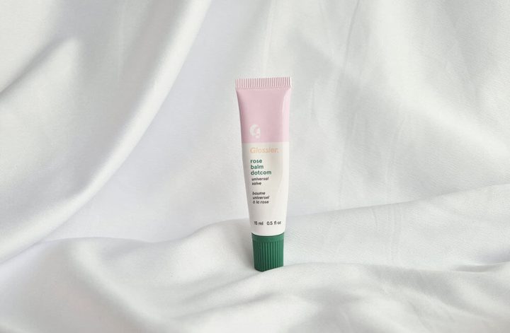 Baume à lèvres Balm Dotcom Glossier posé sur un tissu blanc.