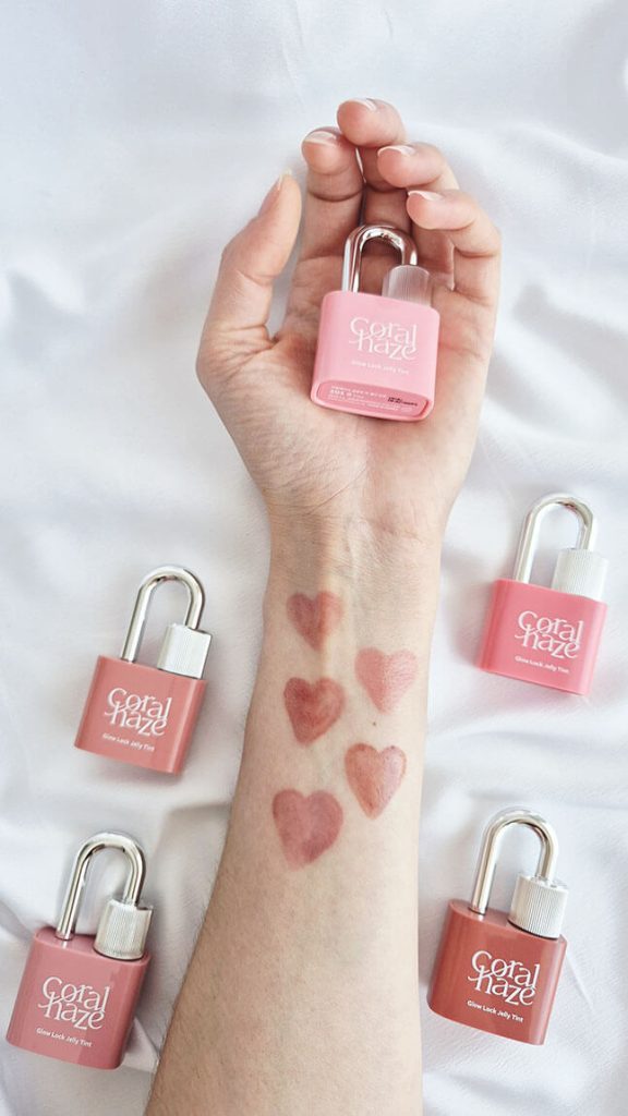 Swatches des cinq teintes Glow Lock Jelly Tint Coralhaze dessinés en forme de cœur sur un avant-bras.