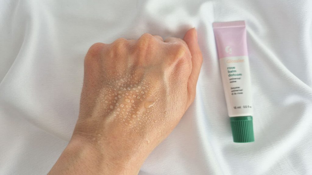 Film protecteur brillant laissé sur la peau après application du Balm Dotcom Glossier.