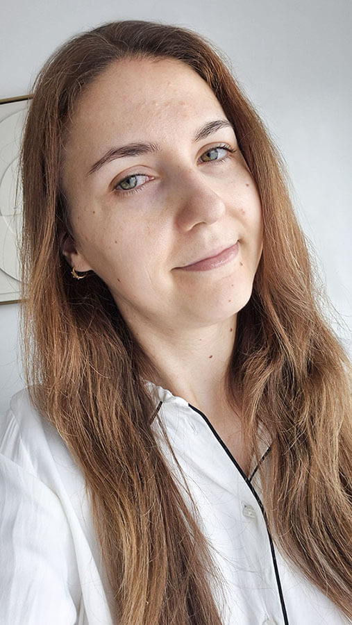 Portrait de Tatiana souriante montrant une peau apaisée avec de l'acné et plus équilibrée