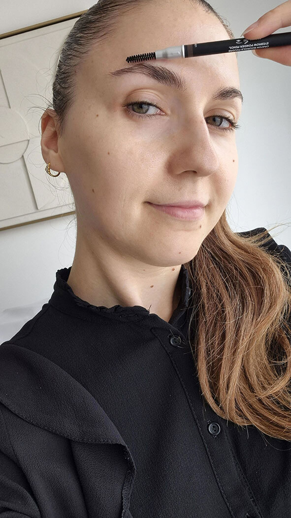 Femme brossant ses sourcils vers le haut avec un goupillon avant d'appliquer le feutre Judydoll