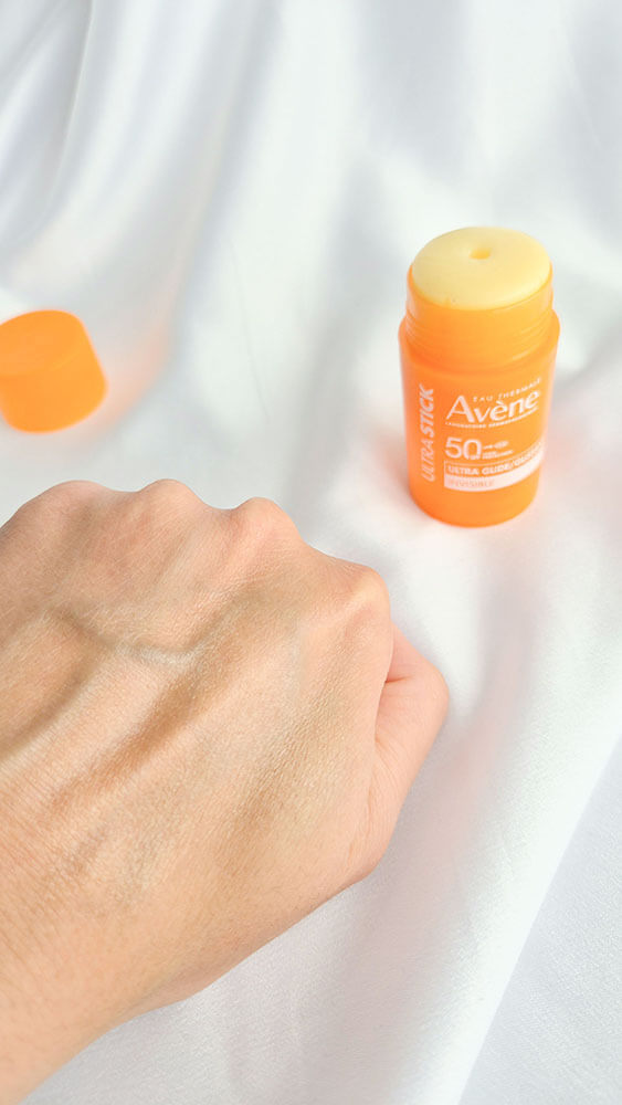 Swatch de l'Ultra Stick Invisible SPF 50 d'Avène appliqué sur le dos de la main.