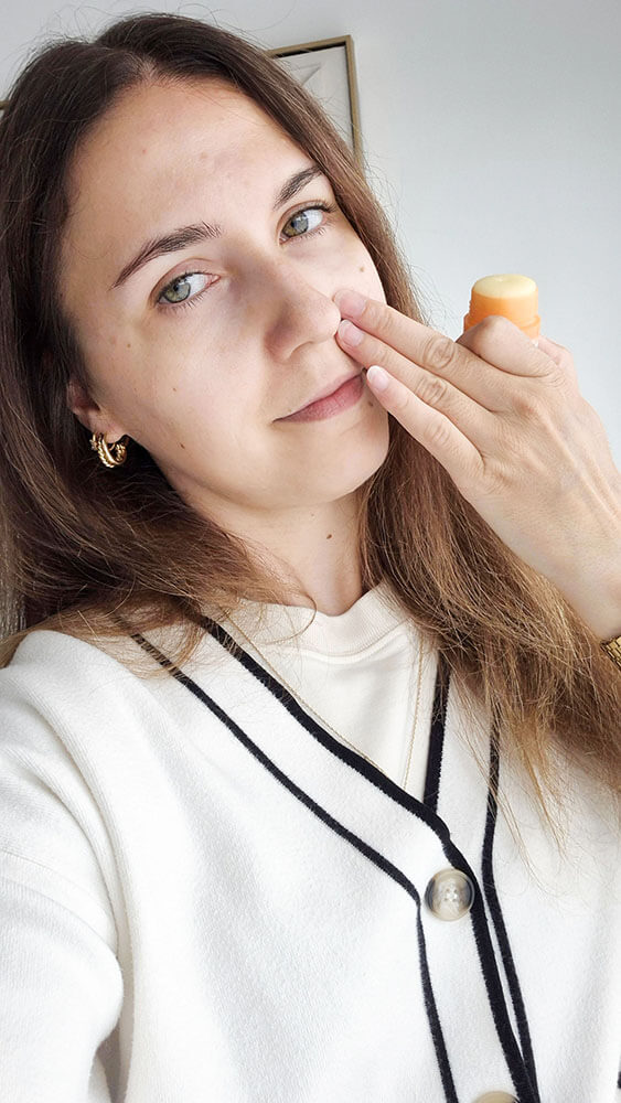 Étalage avec les doigts de la texture baume de l'Ultra Stick Invisible SPF 50 d'Avène sur le visage.